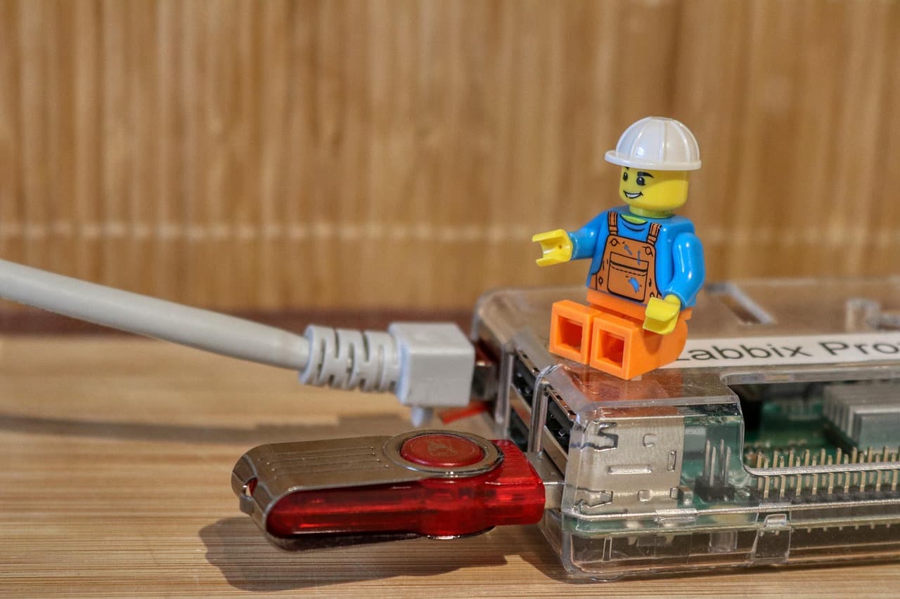 Uma pen USB segurada ao lado de um portátil