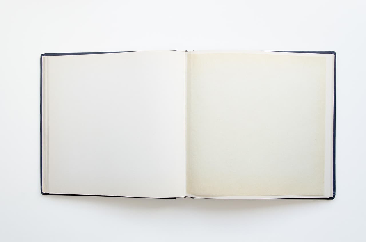 An open photo album showing two entirely blank pages on a white background